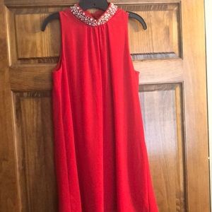 Red party dress with pearl collar and keyhole back